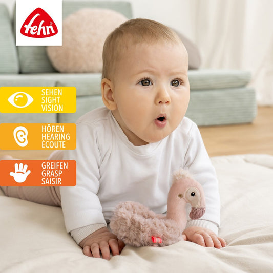 Zachte flamingo rammelaar ring van Fehn, ideaal babyspeelgoed om te grijpen, voelen en luisteren.