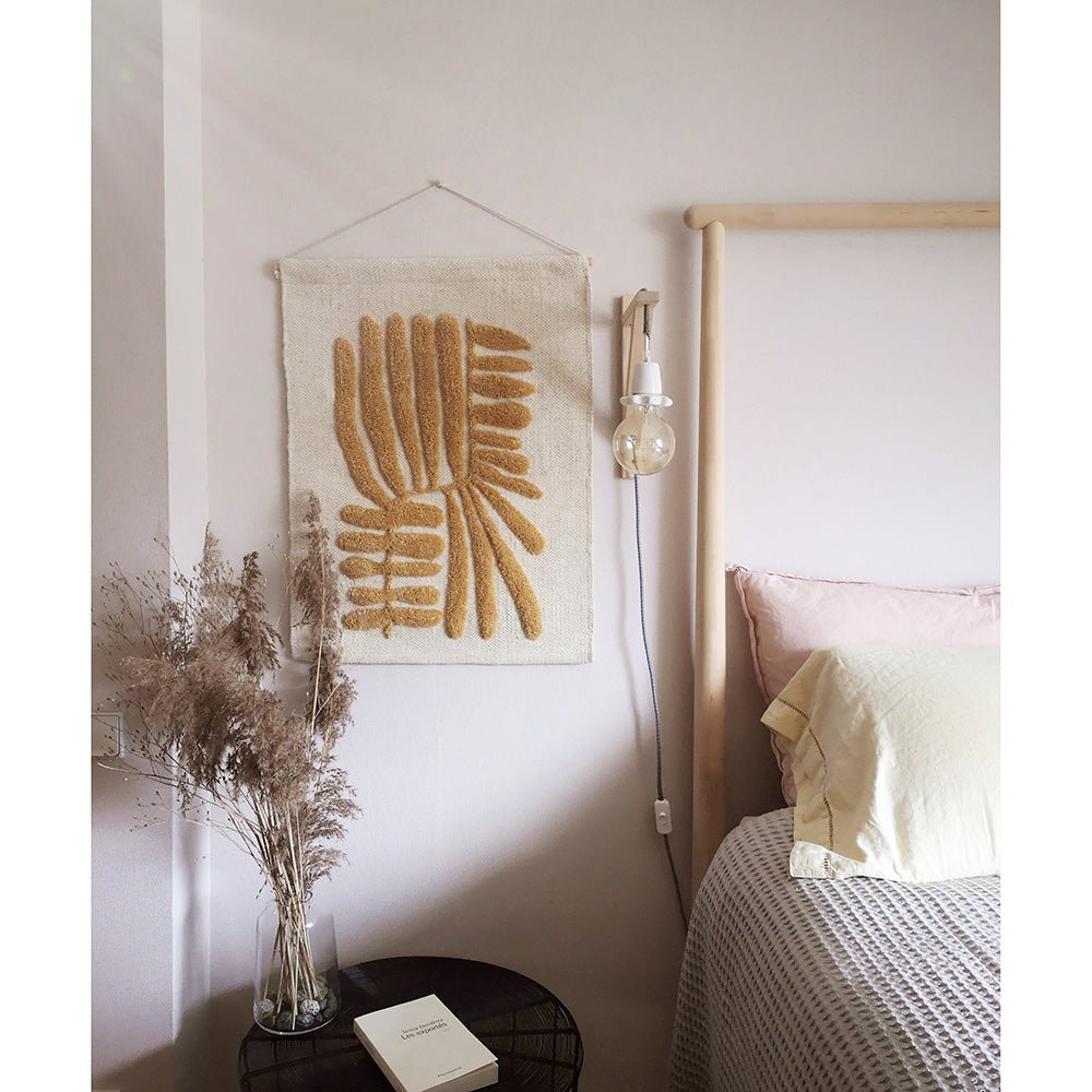 Wandkleed Minerva in okergeel en beige met bladmotief – bohemien muurdecoratie van wol.