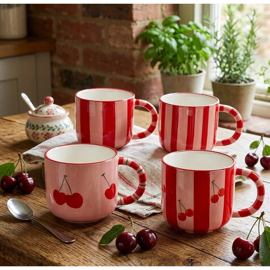 Sfeerimpressie van de vier kersenmokken gepresenteerd op een robuuste houten tafel voor een landelijke uitstraling.