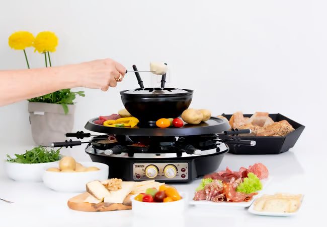 Presentatie van de Zanussi 4-in-1 set op een gedekte tafel met diverse bijgerechten.