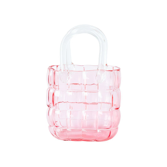 Elegante roze glazen vaas in de vorm van een handtas tegen een witte achtergrond.