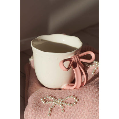 Sfeerimpressie van de Ribbon Grace mok geplaatst op een zacht roze kleed.