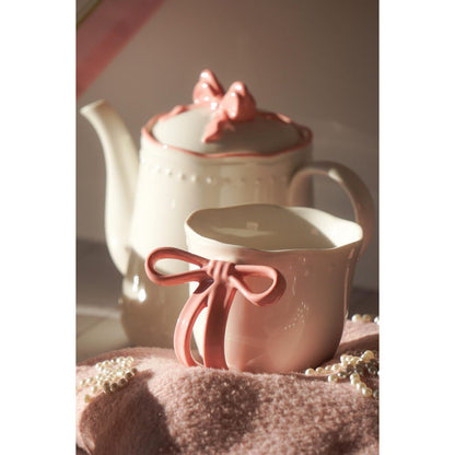 Sfeerimpressie van de Ribbon Grace theeset met de roze lint mok op de voorgrond en de theepot op de achtergrond.