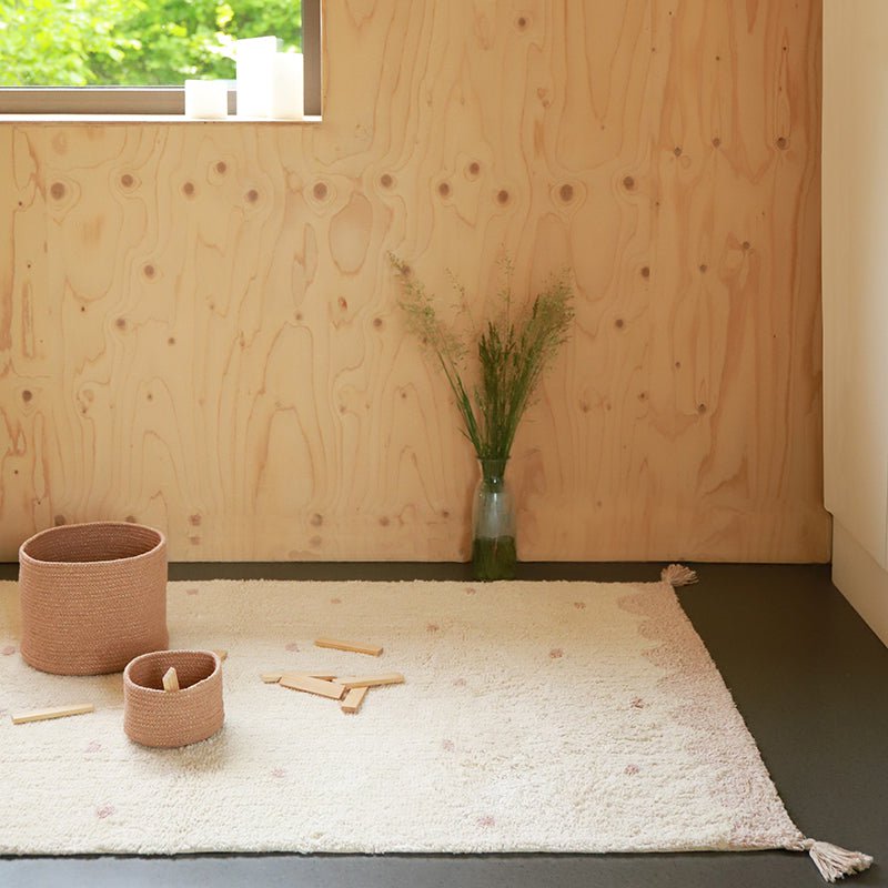 Vloerkleed Minna Roze met Stippen van Nattiot – vierkant katoenen vloerkleed met witte basis en speelse roze stippen, perfect voor de kinderkamer.