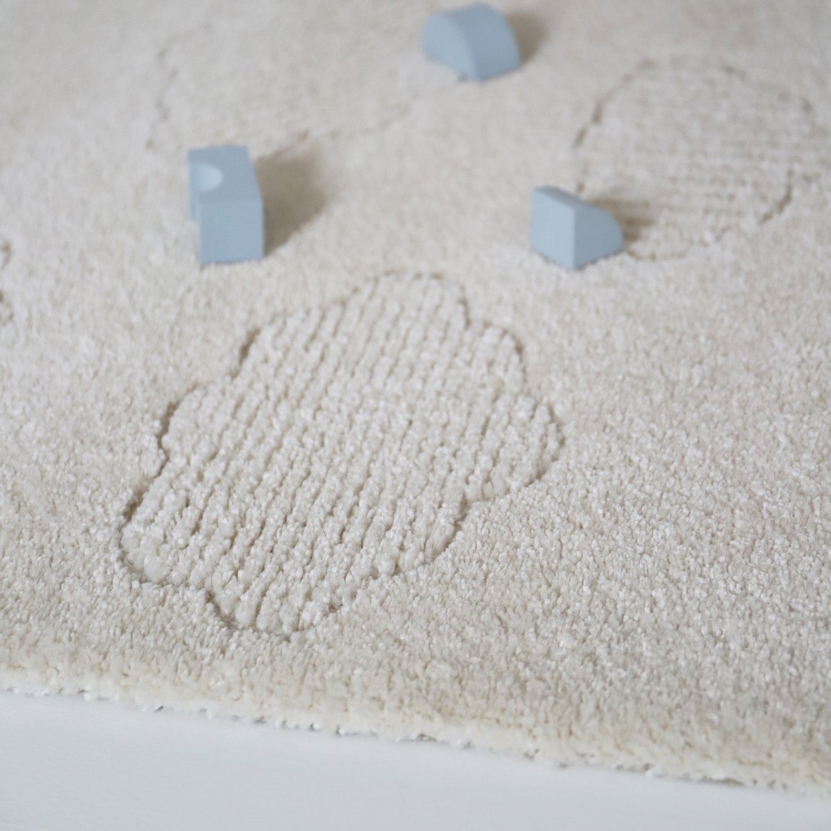 Zacht Nouby vloerkleed van Nattiot met wolkenpatroon in beige en wit, ideaal voor babykamer of kinderkamer.