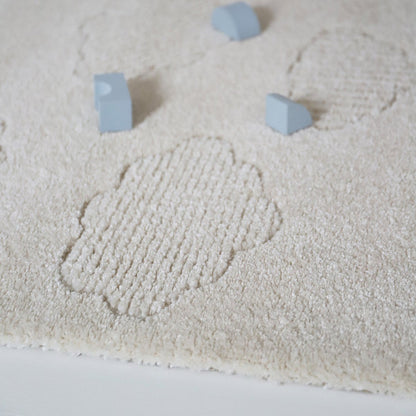 Zacht Nouby vloerkleed van Nattiot met wolkenpatroon in beige en wit, ideaal voor babykamer of kinderkamer.