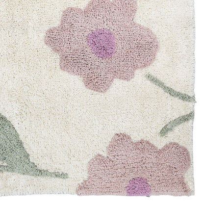 Close-up detail van de zachtpaarse bloemen op het handgemaakte katoenen Sunny Flowers vloerkleed.