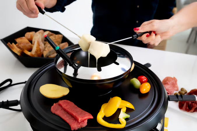 Bovenaanzicht van de Zanussi set in gebruik als kaasfondueset met stokjes brood en groenten op de grill.